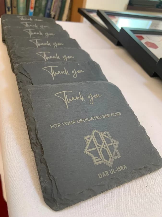 A row of engraved thank-you slate coasters